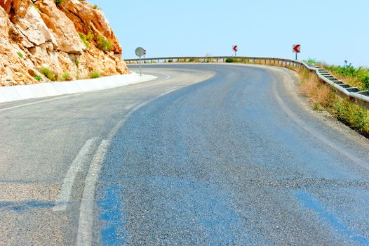 paved road in the mountains under the scorching sun