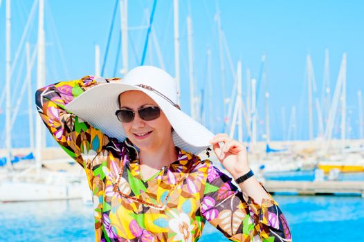 Portrait of a woman in white panama hat on a background of yachts