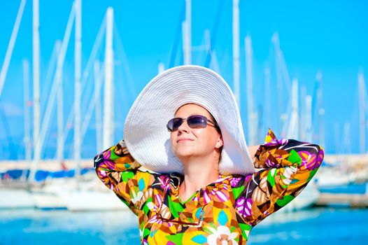 Portrait of a woman in panama hat on a background of yachts