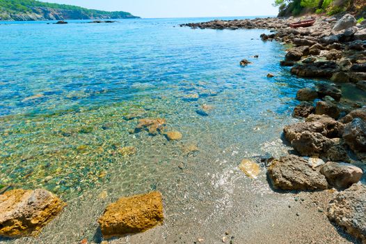 boulders on the shore of a clean and calm sea