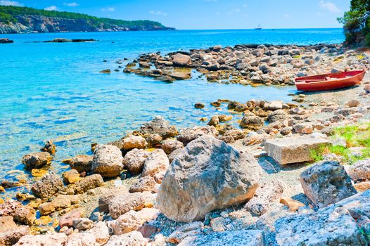 large boulders on the beach and boat