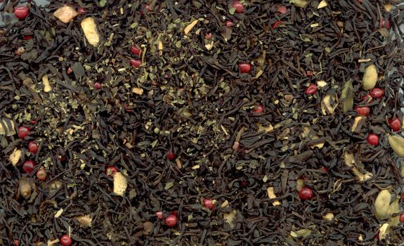 Indian masala tea with pink peppercorn as background