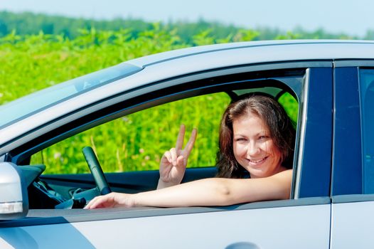 smiling girl driving a car on nature