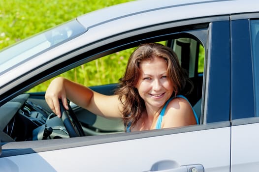Portrait of a cheerful woman driving a car