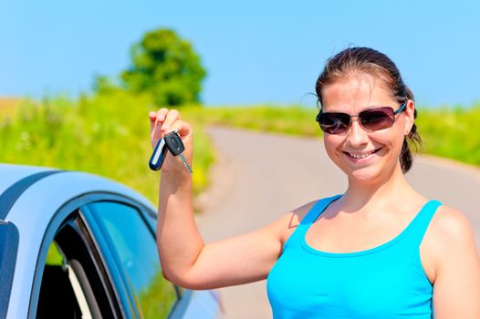 young woman proudly displays the keys to her new car