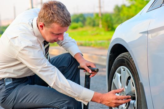 businessman pumps car tire pump