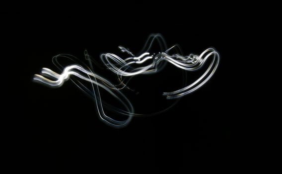 Curved white lines. Abstract wave forms of light in long exposure.