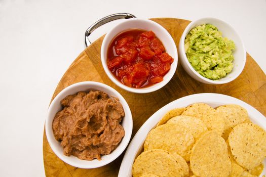 Food Appetizers Chips and Salsa Refried Beans Guacamole on Wood Cutting Board