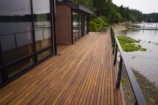A beautiful waterfront home has the water view from the back wood deck