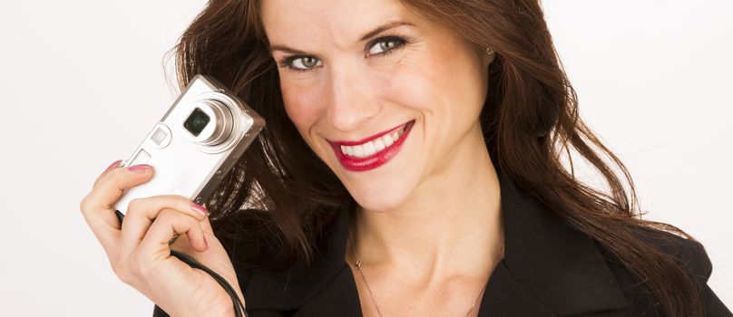 A woman holds camera off to the side smiling at viewer
