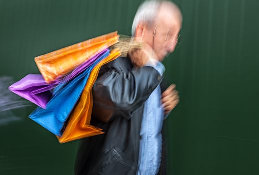 Holiday sales. Man with many shopping bags in his hand. Intentional motion blur