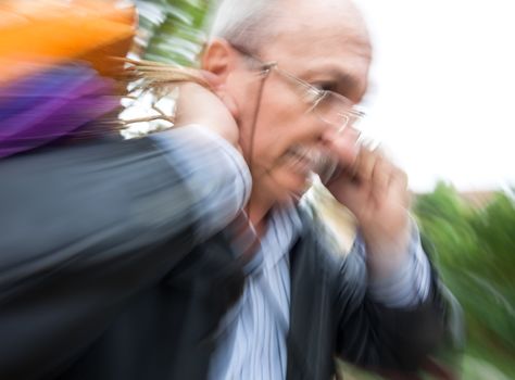 Holiday sales. Man with many shopping bags in his hand talking on a cell phone. Intentional motion blur