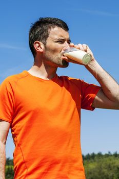 man is drinking fresh glass of milk in the blue skye