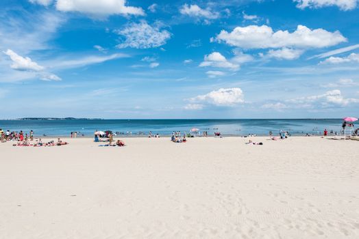 Summer scene of a large public beach with people having fun