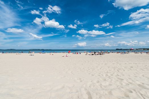 Summer scene of a large public beach with people having fun