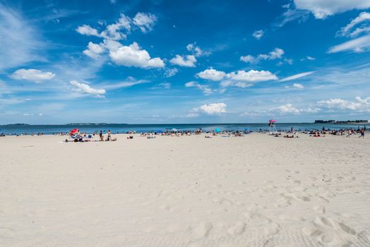 Summer scene of a large public beach with people having fun