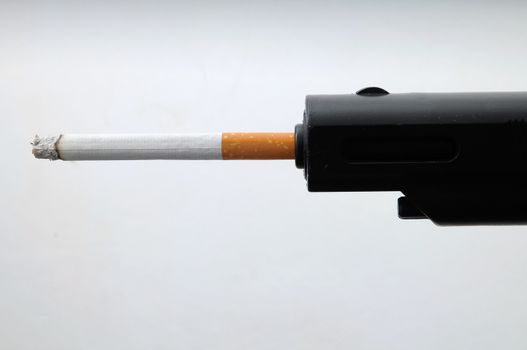 Black Gun Shooting Cigarette on a White Background
