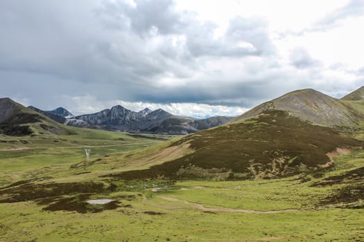 Scenic landscape with mountains, fields, forests, and clouds