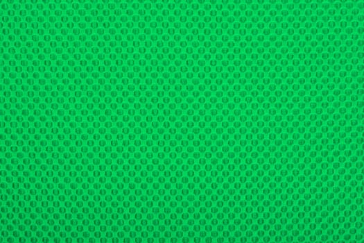 Green fabric with dots, a textile background.