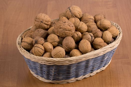 Nuts in a basket on a wooden background