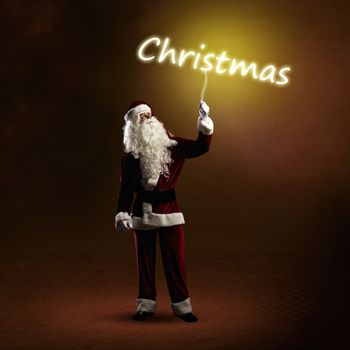 Santa Claus is holding a shining Christmas word sign on a string