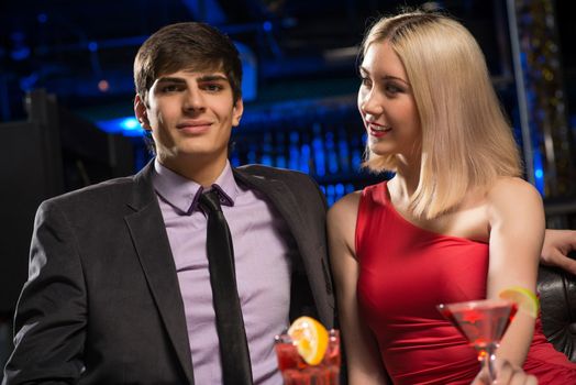 Young couple talking in a nightclub, have fun