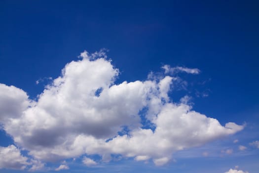 Cloudscape background with blue sky and low fluffy clouds