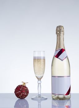 Champagne glass, bottle, and New Year decoration, studio shot on grey background 