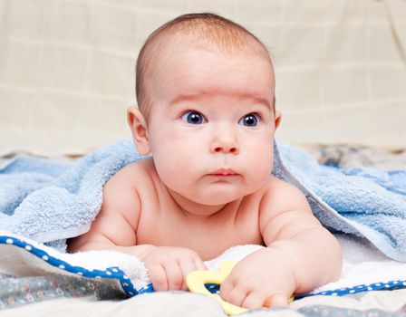 Little baby girl lying under towel