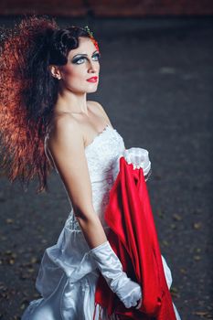 Attractive bride in a wedding dress with bright makeup, red shawl