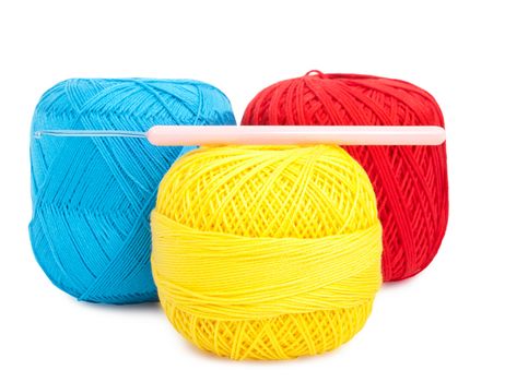blue, yellow and red ball of yarn with hook for knitting