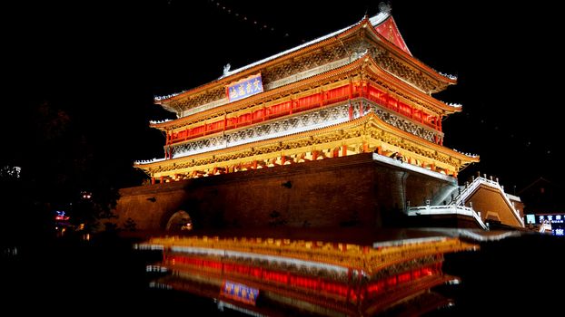 The illuminated ancient Drum Tower located inside the ancient city wall at night time, Xian, Shaanxi Province, China 