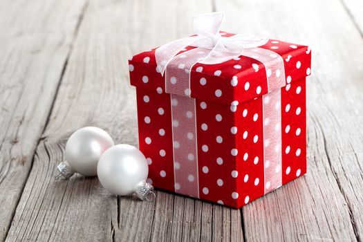 red gift box, polka dots, on wood background