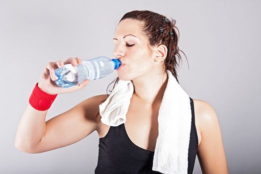 portrait of attractive girl drinking water after exercises