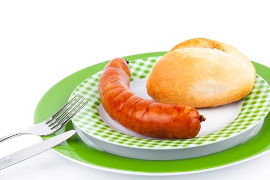 Stack of cooked sausages on a plate with bun