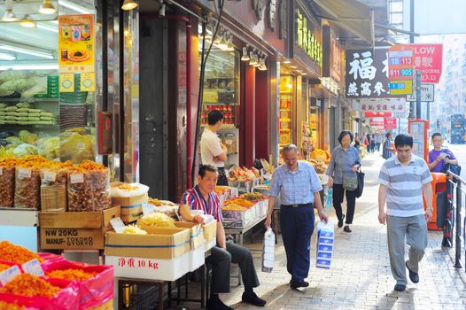 Hong Kong - May 17, 2013: People walking at a street market in Hong Kong. With a land mass of 1,104 km and population of 7 million people, Hong Kong is densely populated areas in the world