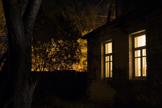 Night view of the rural house with lighted windows