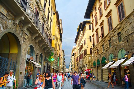 Florence, Italy - September 8, 2013: Tourists strolling in crowded street of old town after the rain in Florence.
