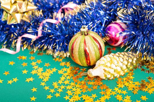 Christmas toy on a green background, blue tinsel.