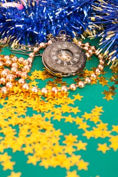 Christmas toys with clock on green background