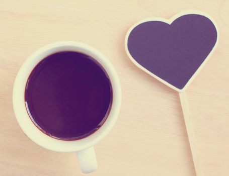 Black coffee and heart shape blackboard with retro filter effect
