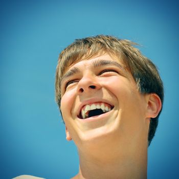 Vintage photo of cheerful teenager portrait on the blue sky