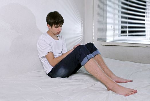 Sorrowful Young Man sitting on the bed Alone