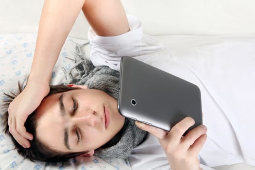 Young Man with Tablet Computer on the bed