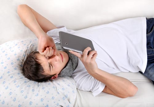 Young Man with Tablet Computer on the bed