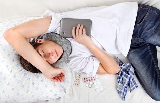 Sick Teenager sleeps with Tablet Computer