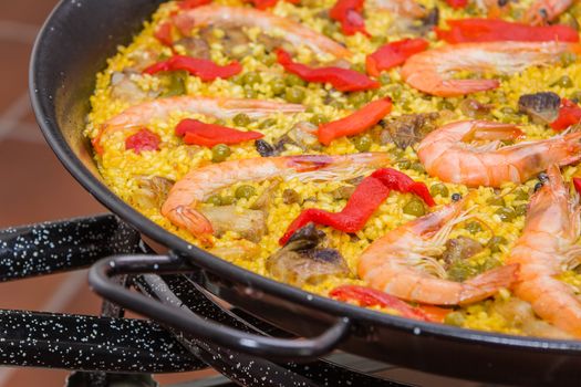 Closeup of traditional spanish paella cooked in a pan, with yellow rice and seafood