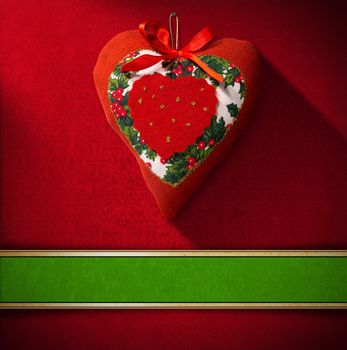 Christmas heart hanging on red velvet background with ornate floral seamless and green plaque