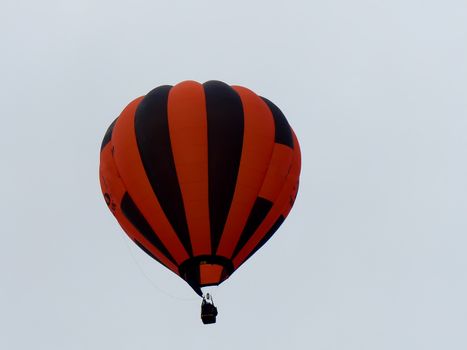 orange striped hot air balloon in flght