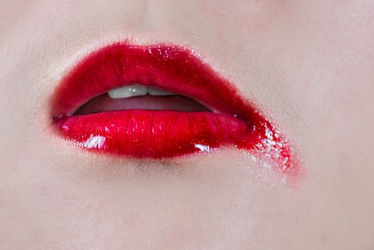 Woman lips with lipsticks smeared on skin